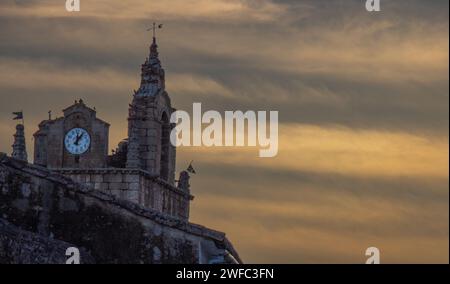 Colores en el cielo del atardecer y detalle de la torre de la iglesia de Santa Marina en Cañaveral, Cáceres, España Stock Photo