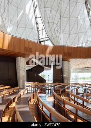 Temple interior with timber benches, balcony, stairway and view of translucent wings. Baháí Temple of South America, Santiago, Chile. Architect: Hari Stock Photo