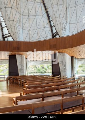 Temple interior with timber benches, balcony and view of translucent wings. Baháí Temple of South America, Santiago, Chile. Architect: Hariri Pontari Stock Photo