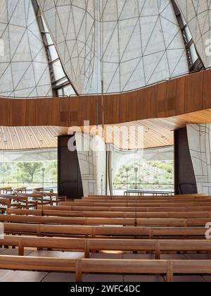 Temple interior with timber benches, balcony and view of translucent wings. Baháí Temple of South America, Santiago, Chile. Architect: Hariri Pontari Stock Photo