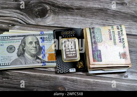 Cairo, Egypt, January 25 2024: Egyptian pounds, American dollars, Akef pure fine silver Ounce 1 OZ 31.1 grams bar, silver investment, exchange price r Stock Photo