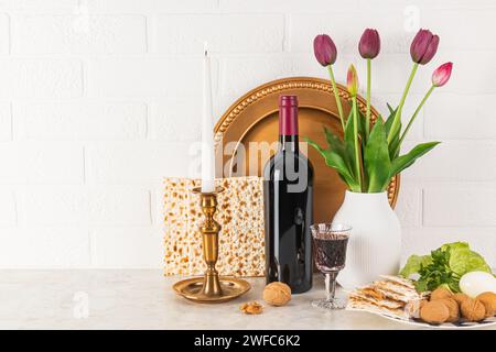 Beautiful still life for the spring holiday of Jewish Passover. Front view of traditional products for holiday, matzoth, bottle of red wine, dish Stock Photo