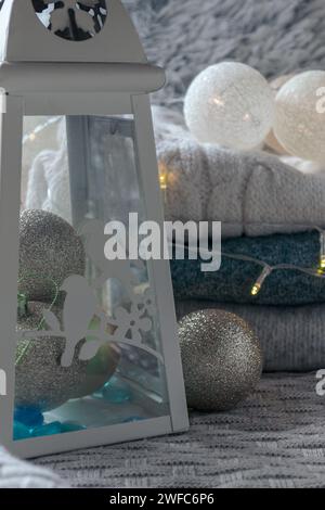 lantern-candlestick and Christmas decorations on a knitted blanket with a garland Stock Photo