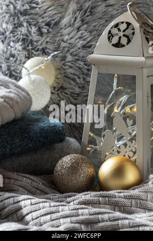 two Christmas balls on a knitted plaid against the background of Christmas garlands Stock Photo