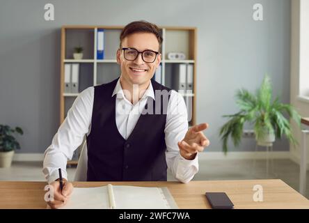 Happy smiling young business man having online video call sitting in office. Stock Photo