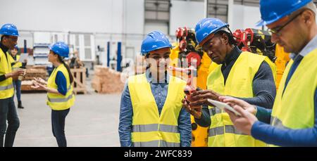 Multiracial engineers working inside robotic factory - Technology, machine learning and artificial intelligence concept - Soft focus on girl face Stock Photo