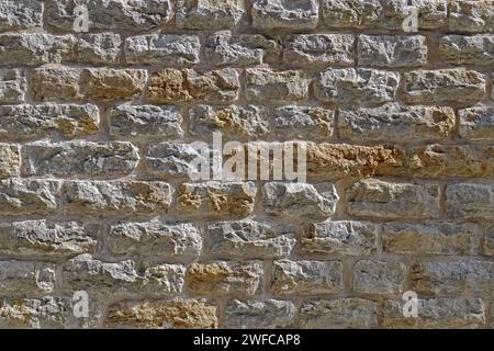 Beige stone wall background. Detail of a medieval stone wall. Seamless texture. Stock Photo