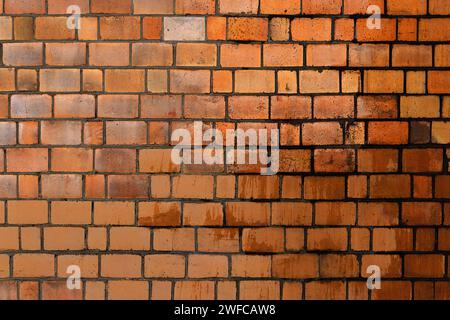 old wet wall with water dripping from up to down on the orange bricks, background texture Stock Photo