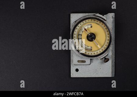 Old geological compass on dark background close up. Stock Photo