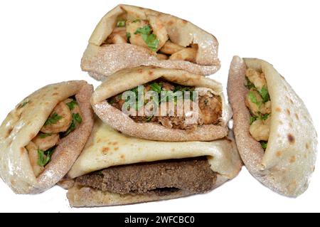 Background of fried shrimps, beef brain, beef liver slices deep fried in oil and served with parsley in a traditional Egyptian flat bread with wheat b Stock Photo