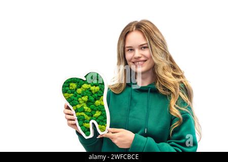 Healthy teeth concept with young woman holding a lichen tooth symbolizing oral care and dental hygiene Stock Photo
