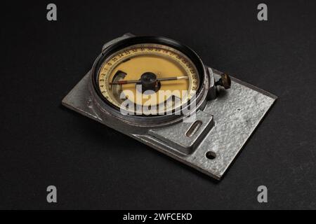 Old geological compass on dark background close up. Stock Photo