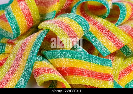 Colorful jelly candies strips in sugar sprinkles. Sour flavored rainbow candy background Stock Photo