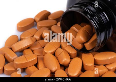 Brown pills medication in pile on white background. Stock Photo