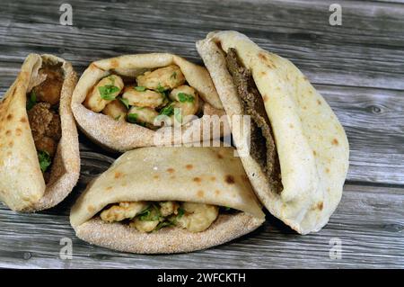 Background of fried shrimps, beef brain, beef liver slices deep fried in oil and served with parsley in a traditional Egyptian flat bread with wheat b Stock Photo