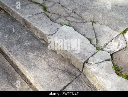 Destroyed and grass-covered steps of a concrete staircase Stock Photo