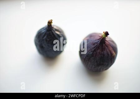 Two ripe sweet figs on white table. Selective soft focus. Blurred. Stock Photo