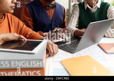 Close up of Black teacher using laptop at desk with two students in college class copy space Stock Photo