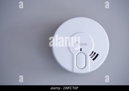 A Kidde 29HD optical smoke alarm installed on the ceiling of a room in a UK home. The battery powered fire alarm conforms to EN14604 Stock Photo