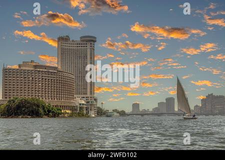 CAIRO, EGYPT - APRIL 26, 2022: View from the Nile river with Four Seasons Hotel Cairo at Nile Plaza, Water Taxi Garden City Station in front Stock Photo