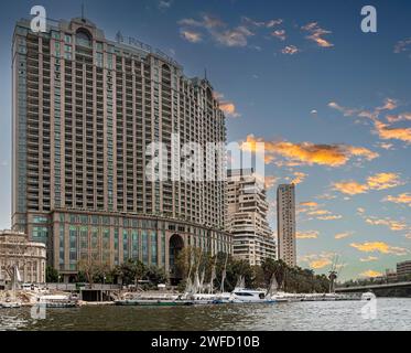 CAIRO, EGYPT - APRIL 26, 2022: View from the Nile river with Four Seasons Hotel Cairo at Nile Plaza, Water Taxi Garden City Station in front and other Stock Photo