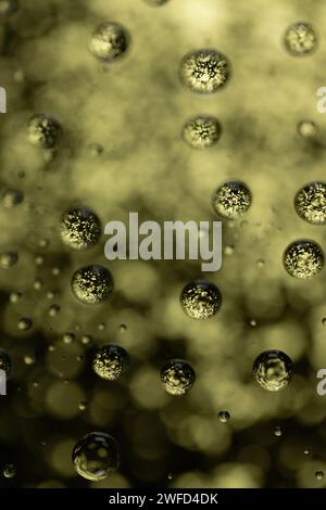 Background of gold bubbles against gold bokeh, close up. Stock Photo