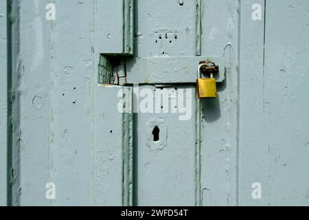 Padlock on gray wooden gate forming a textured background. Stock Photo