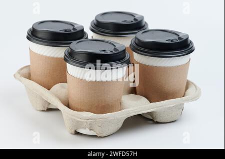 Takeaway delivery hot drinks theme. Paper cups in holder isolated Stock Photo
