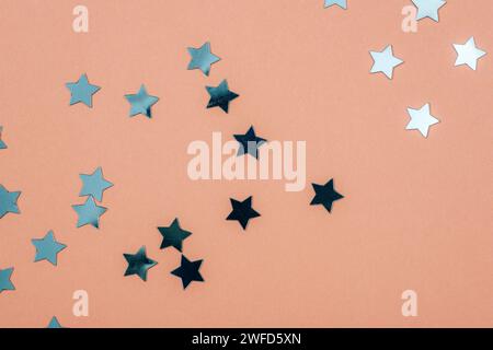 Blue confetti on pink background. Birthday party, holiday concept. Top view, copy space. Stock Photo