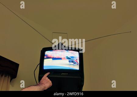 finger pushing button of tv mounted on wall Stock Photo