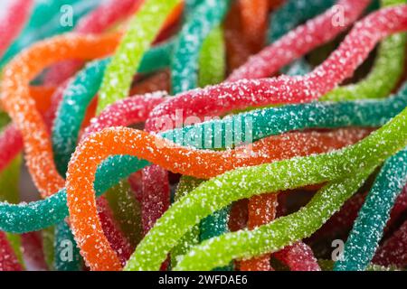 Multicolored jelly candies in the shape of the spaghetti sprinkled with sugar. Close up. Stock Photo