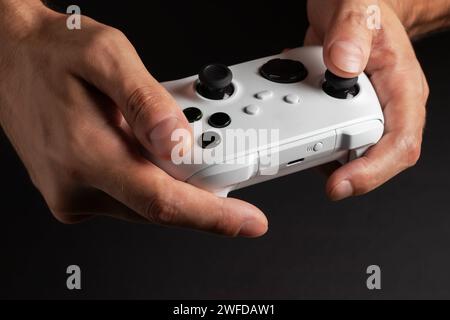 White next gen controller in man hands on dark background. Stock Photo