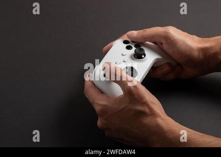White next gen controller in man hands on dark background. Stock Photo