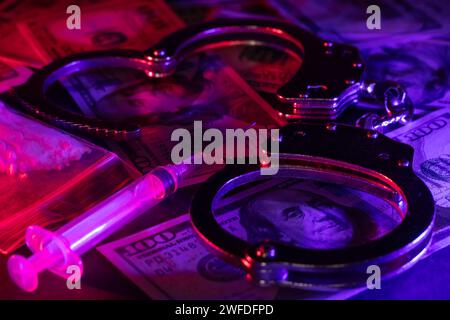 Drug smuggling and trafficking and handcuffs side gun money and bags of cocaine on black background. Business with illegal substances and arrest Stock Photo
