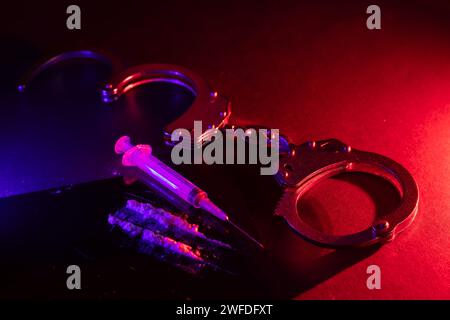 Drug smuggling and trafficking and handcuffs and bags of cocaine on black background. Business with illegal substances and arrest Stock Photo