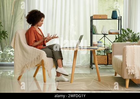 Entrepreneur talking to colleagues in online meeting, discussing ideas for company development Stock Photo