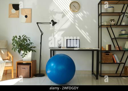 Home office of freelancer software developer with fitness ball instead of chair Stock Photo