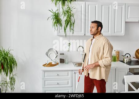 handsome blind indian man in casual cozy homewear using walking stick while at home, disabled Stock Photo