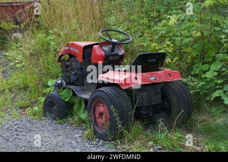 Old red Massey Ferguson All Terrain Vehicle with damaged front end. Stock Photo