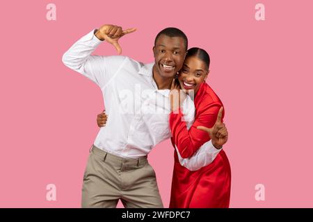 Playful couple making fun hand gestures, joyful Stock Photo