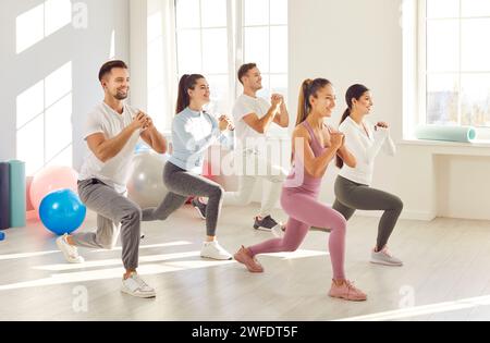 Team Of Athletes Doing Squats In The Gym Stock Photo