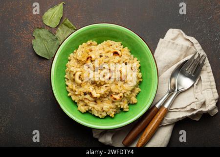 Ven Pongal (Khara Pongal), traditional Indian savoury rice dish made during celebrating Pongal festival, served in bowl top view on concrete rustic Stock Photo