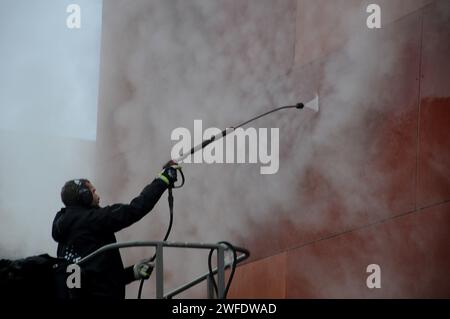 Copenhagen, Denmark /30 January 2024/.Perosn washing and clean building wall in danish capital.   (Photo.Francis Joseph Dean/Dean Pictures) Stock Photo