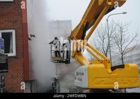 Copenhagen, Denmark /30 January 2024/.Perosn washing and clean building wall in danish capital.   (Photo.Francis Joseph Dean/Dean Pictures) Stock Photo