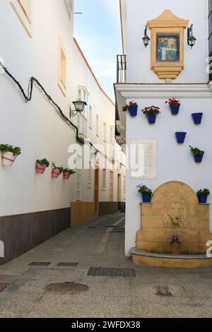 Rota, Cadiz, Spain- October 10, 2023: Narrow streets and whitewashed facades with potted geraniums in Rota Stock Photo