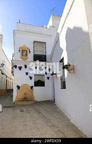 Rota, Cadiz, Spain- October 10, 2023: Narrow streets and whitewashed facades with potted geraniums in Rota Stock Photo