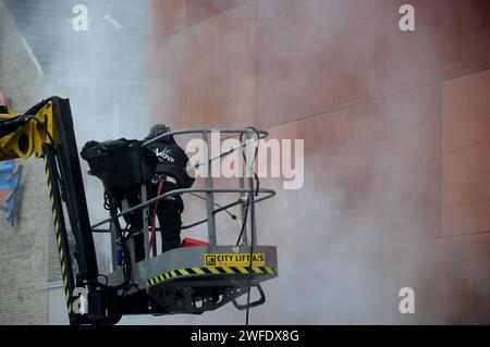 Copenhagen, Denmark /30 January 2024/.Perosn washing and clean building wall in danish capital. Photo.Francis Joseph Dean/Dean Pictures Stock Photo