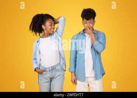 A cheerful young African American woman confidently posing with a hand on her hip Stock Photo