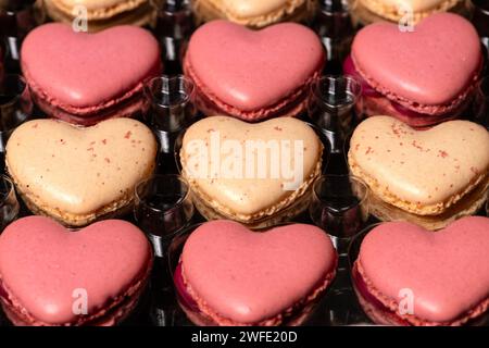 Traditional french baked pastry, heart shaped macarons with vanilla and rasberry favor. Stock Photo