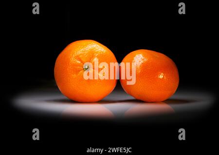 tangerines lie in the dark on the table Stock Photo